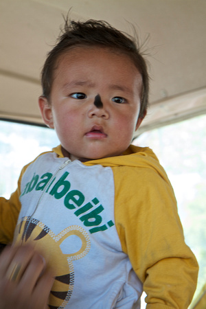 On the minibus from Sera, an infant that has just been blessed by the Tamdrin (馬頭明王).