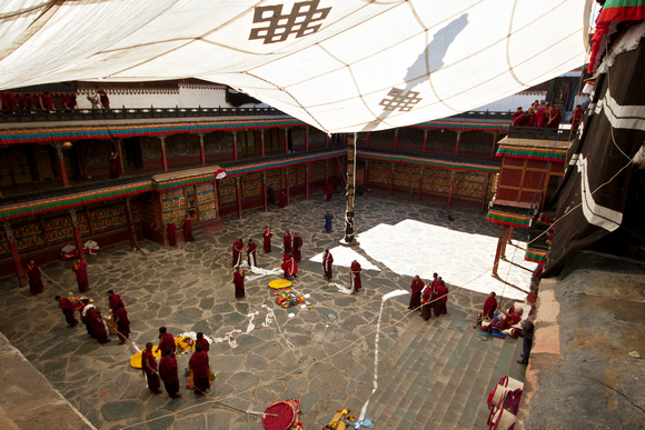 Monks working on something in the courtyard.